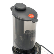 Extracteur de jus professionnel Maxima avec presse-agrumes lent et récipient à jus de 0,8L, en action.